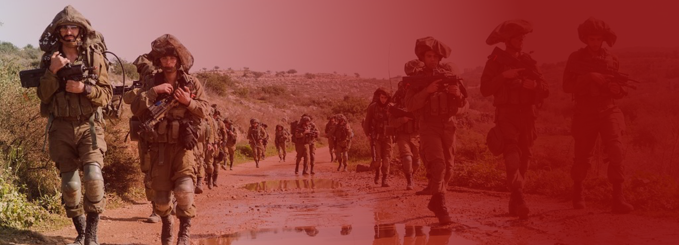 troops in a line moving forward on a desert road